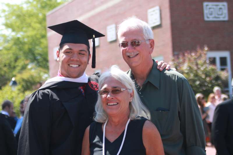 a man in a cap and gown with a man in a graduation cap and gown with a woman in a graduation cap and gown