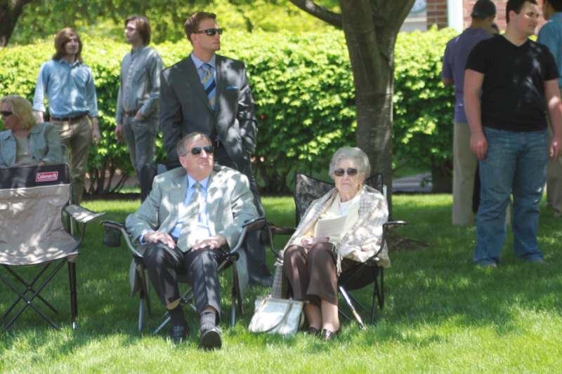 a group of people sitting in chairs in a park