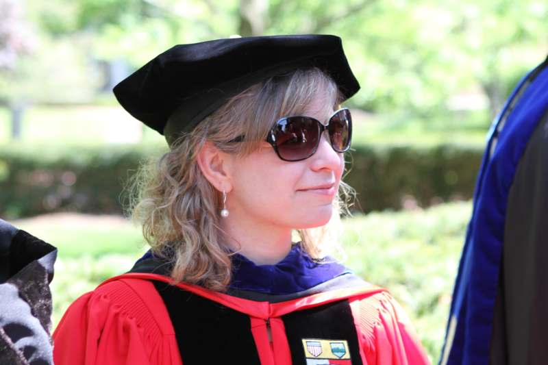 a woman wearing a graduation gown and sunglasses
