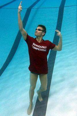 a man in a red shirt and goggles in a swimming pool