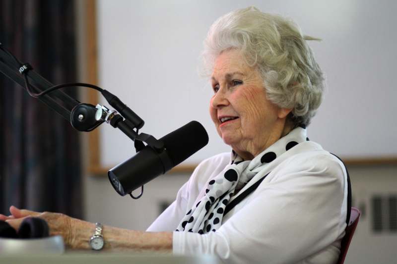 a woman sitting at a microphone