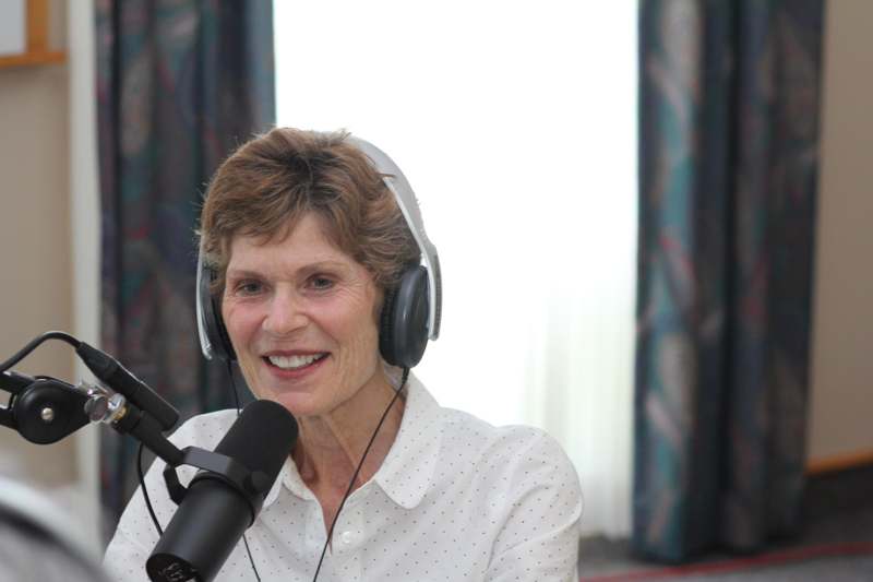 a woman wearing headphones and talking into a microphone