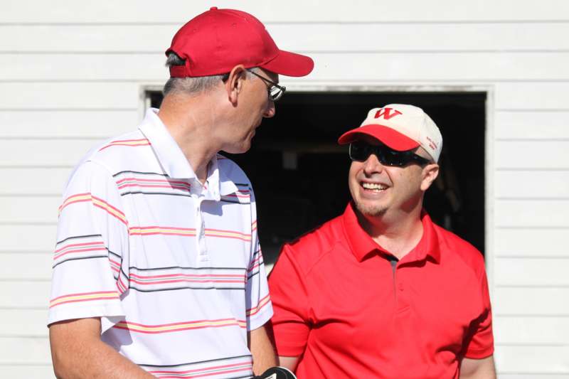 two men wearing red and white shirts and hats
