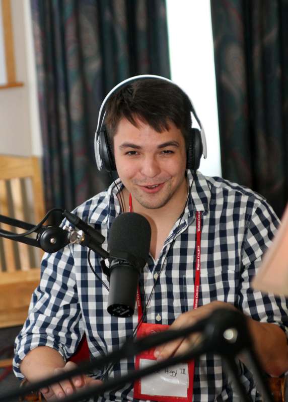 a man wearing headphones and talking into a microphone