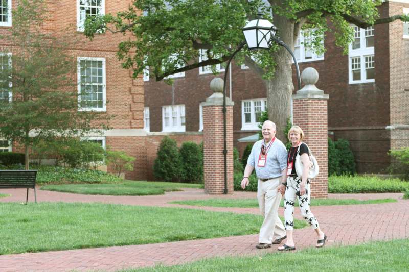 a man and woman walking on a brick path