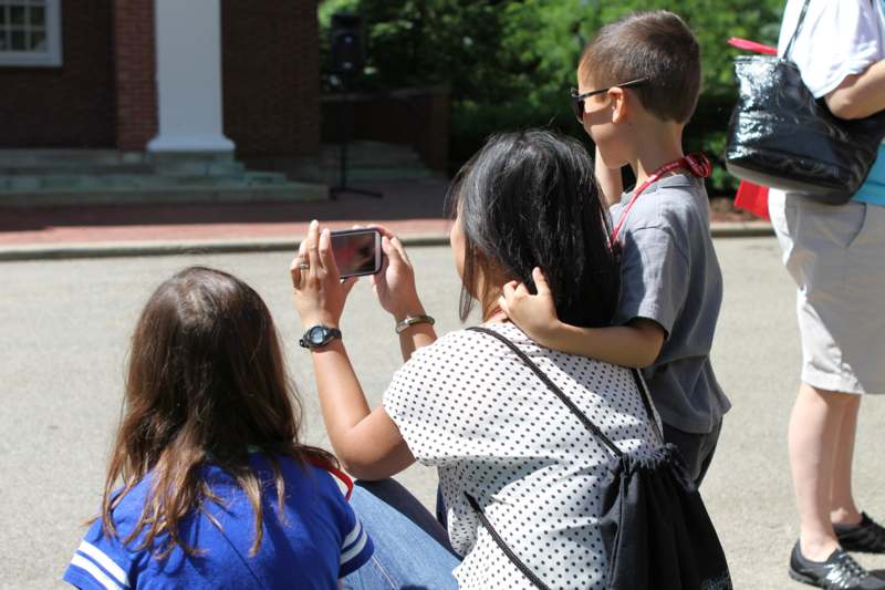 a woman taking a picture of a boy