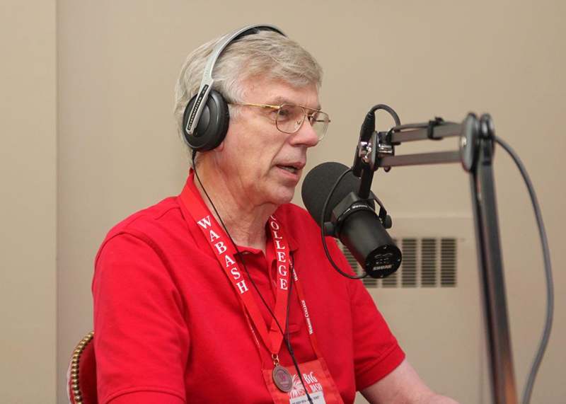 a man wearing headphones and talking into a microphone