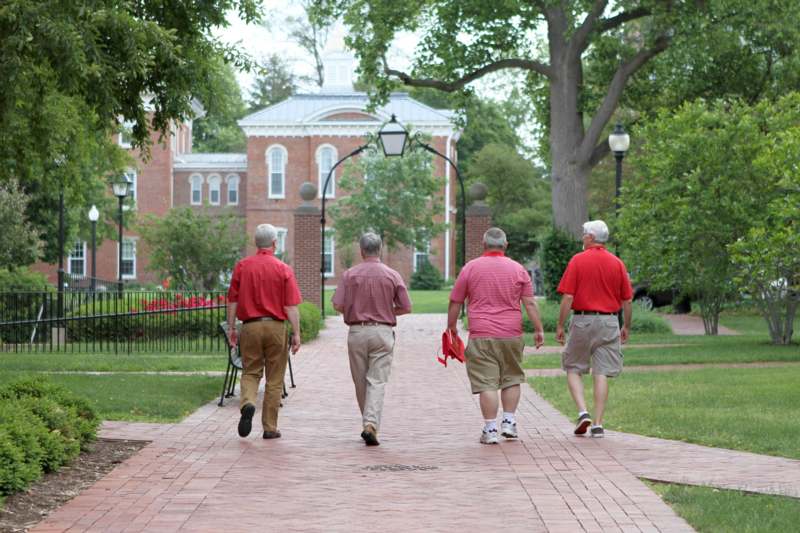 a group of men walking on a brick path