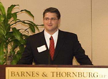 a man in a suit and tie standing at a podium