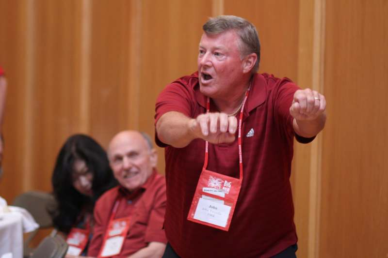 a man in red shirt with his arms raised