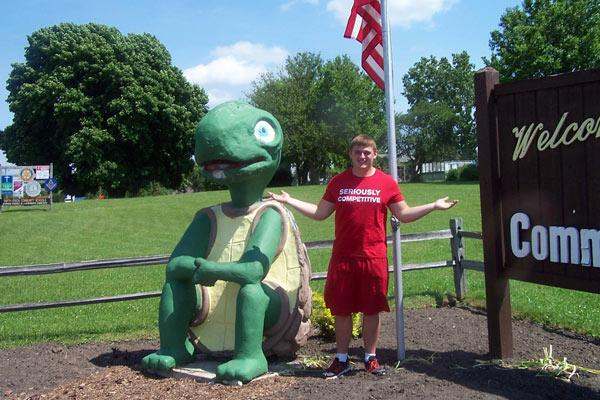 a man standing next to a statue of a turtle