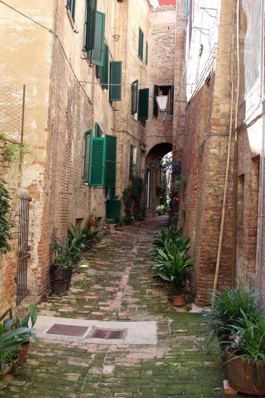 a narrow alley between brick buildings