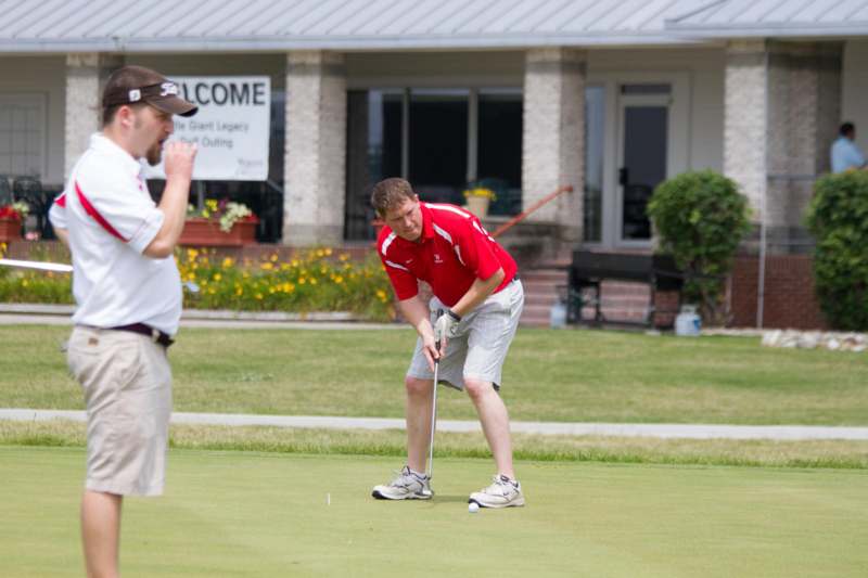 a man in a red shirt playing golf