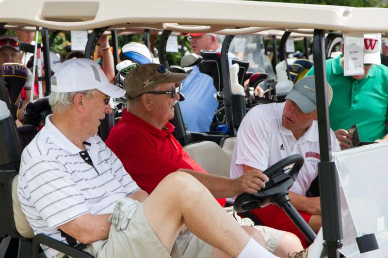 a group of men in golf carts