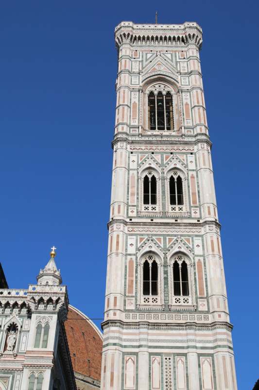 a tall tower with a cross on top with Giotto's Campanile in the background