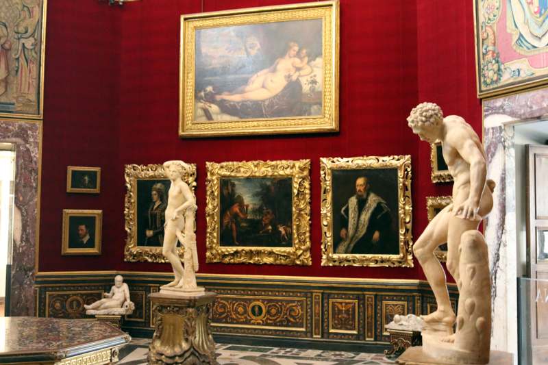 statues in a room with framed art