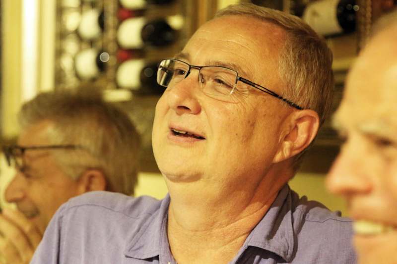 a man wearing glasses and a purple shirt