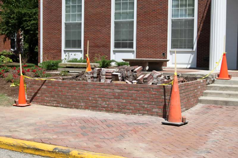 a brick wall with a pile of bricks and a traffic cone