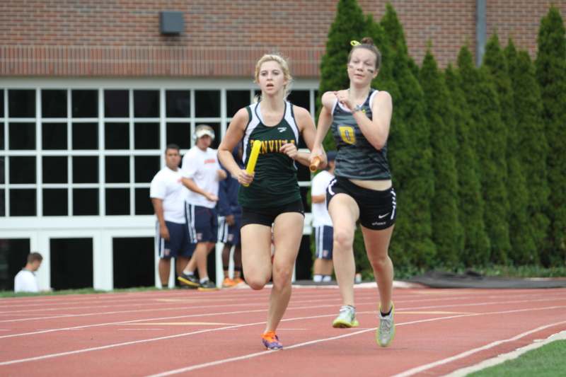 a couple of girls running on a track