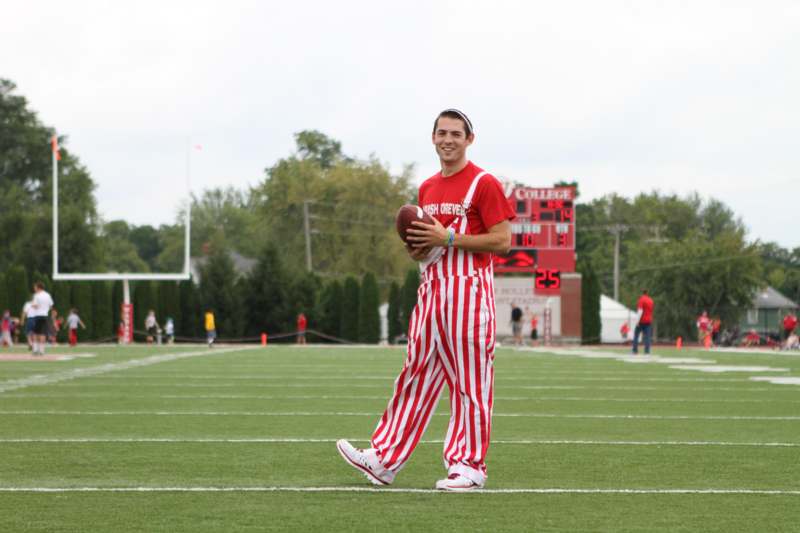 a man in striped pants holding a football