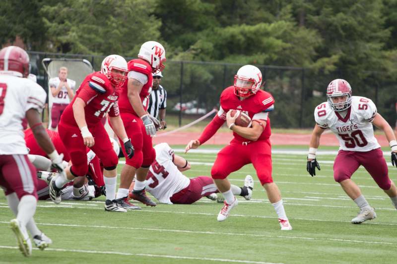 a football player in red uniform running with a football