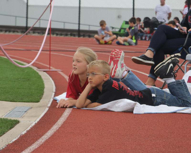 a boy and girl lying on a track
