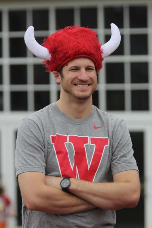 a man wearing a red and white hat with horns