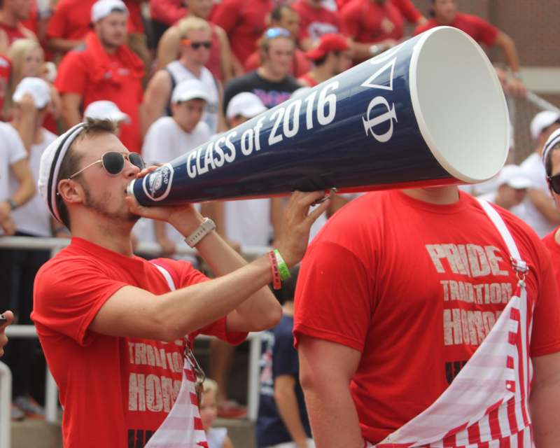a man in red shirt drinking from a megaphone