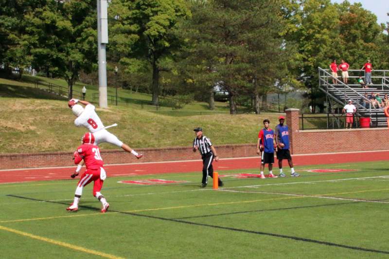 a football player jumping over another football player