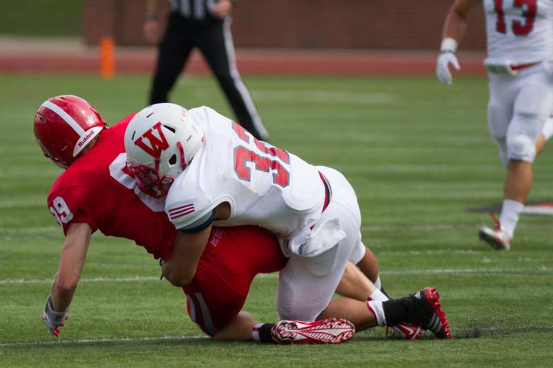 a football player in a red uniform on the ground