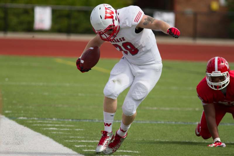 a football player in a white uniform running with a football
