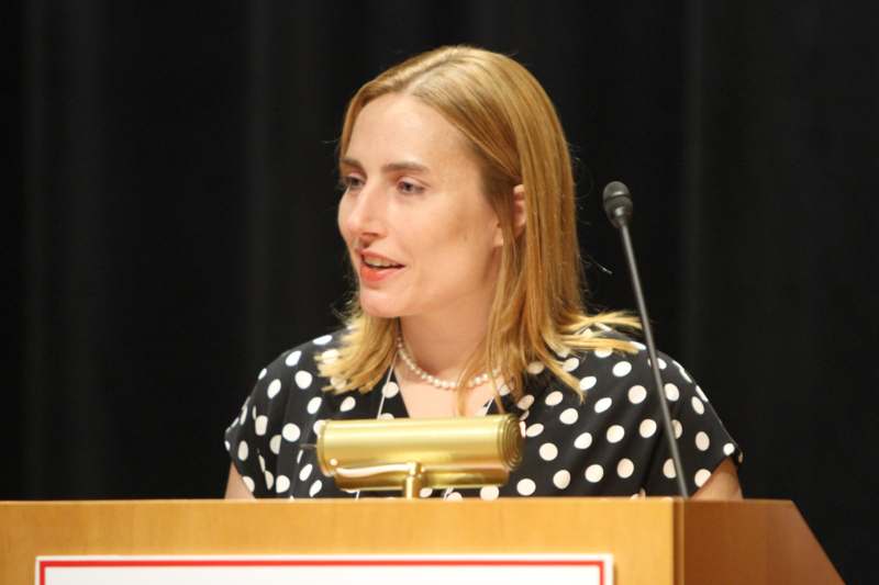 a woman in a polka dot dress at a podium
