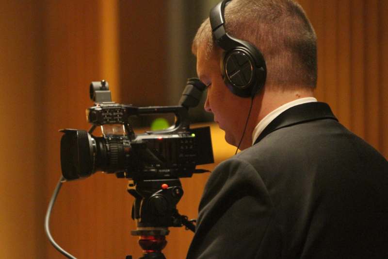 a man wearing headphones and looking through a camera