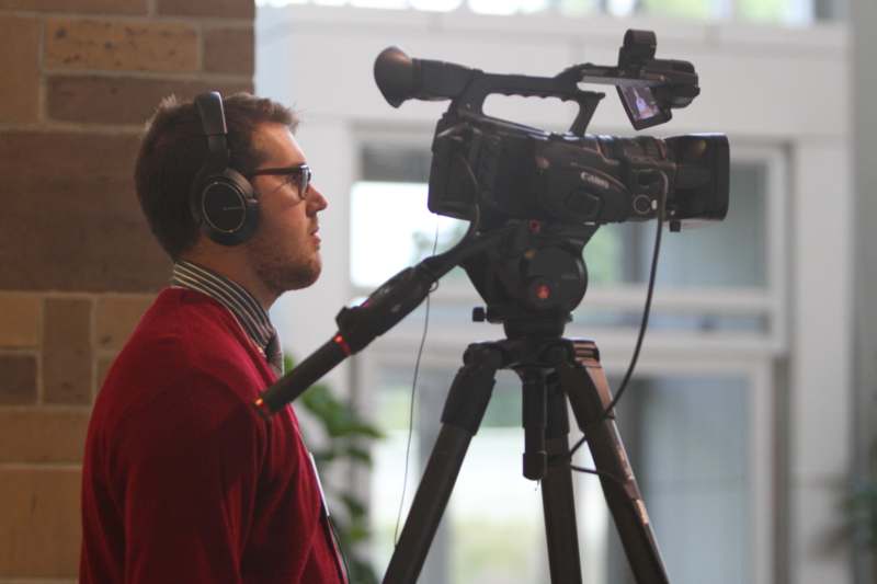 a man with headphones and a camera on a tripod