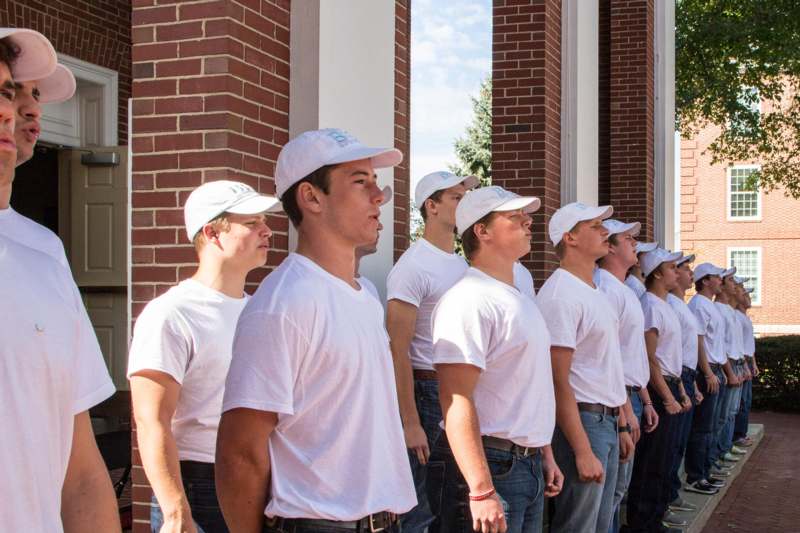 a group of men in white shirts and hats