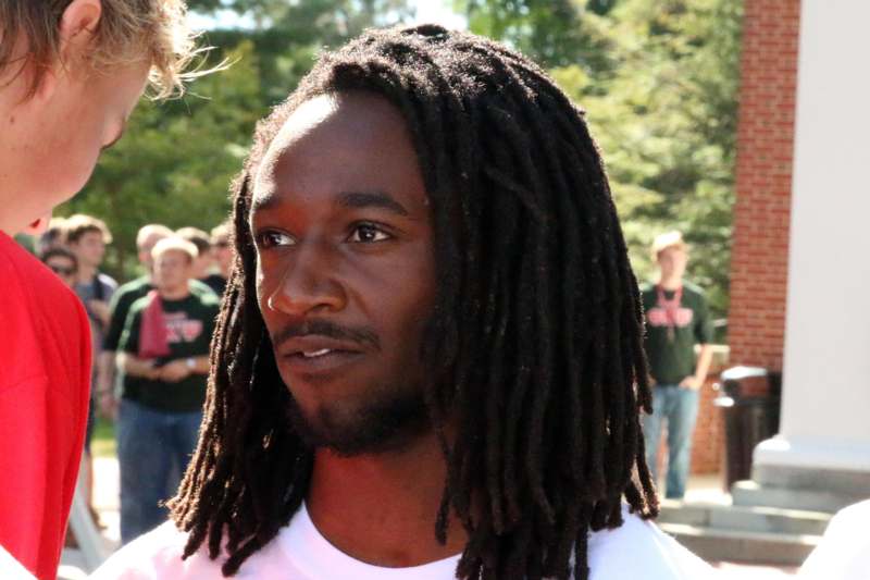 a man with long dreadlocks looking away from camera