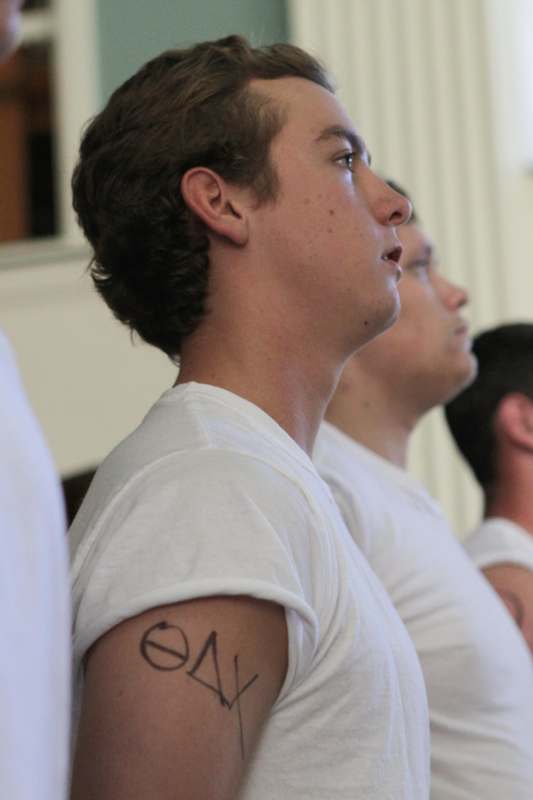 a man in a white shirt with a tattoo on his arm