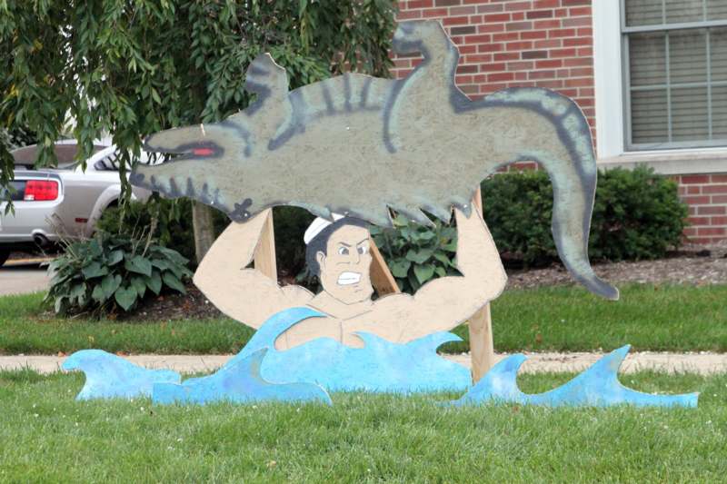a cut out of a man holding a crocodile