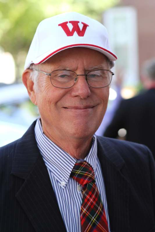 a man wearing a white hat and a suit