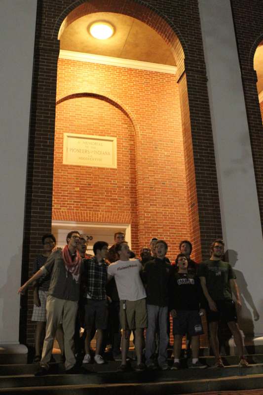 a group of people standing in front of a brick building