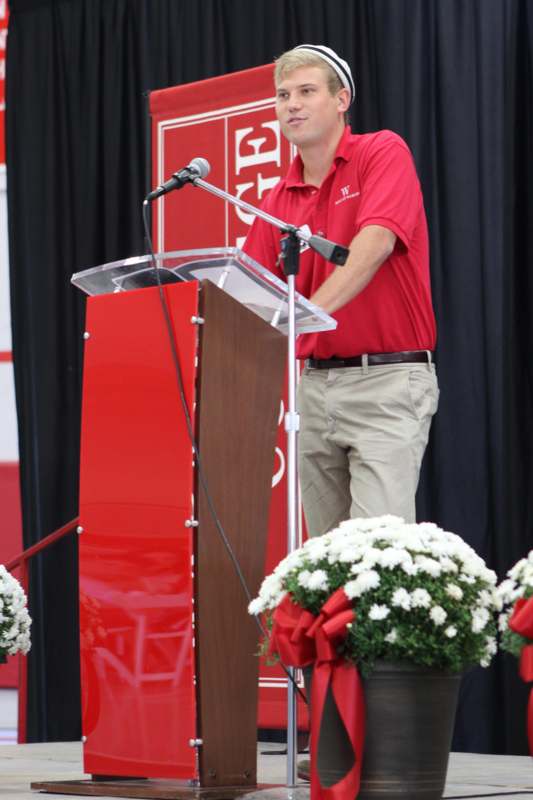 a man standing at a podium with microphones