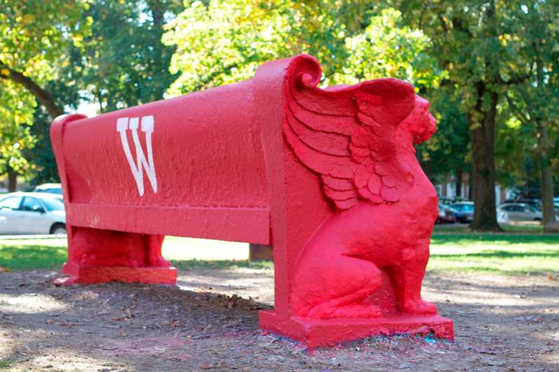 a red bench with a winged animal on it