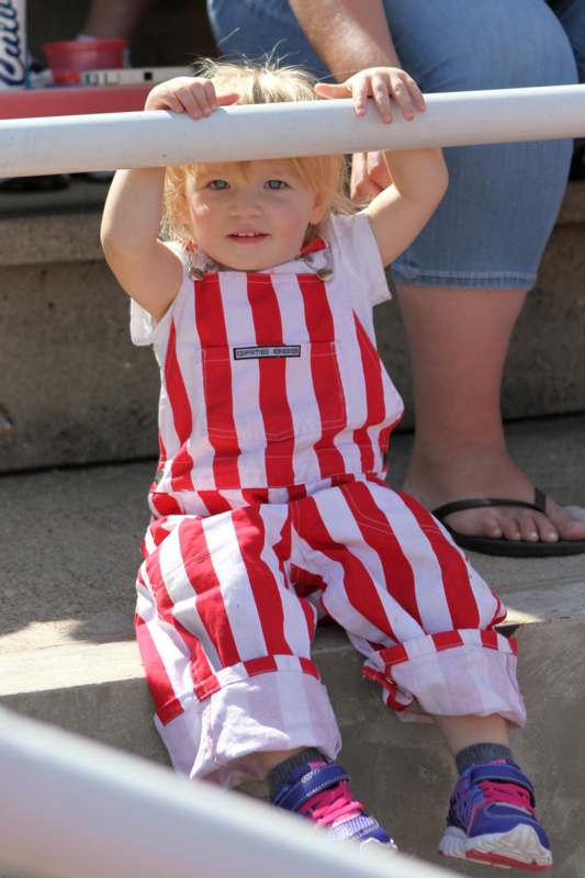 a child in red and white striped overalls