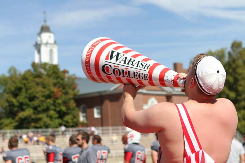 a man in a red and white striped uniform drinking from a megaphone
