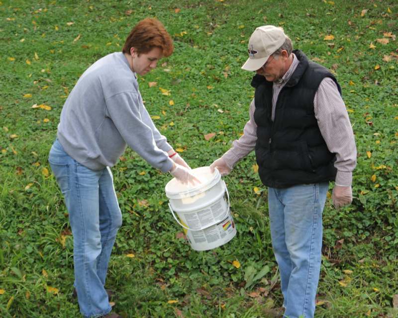 a man and woman holding buckets of paint
