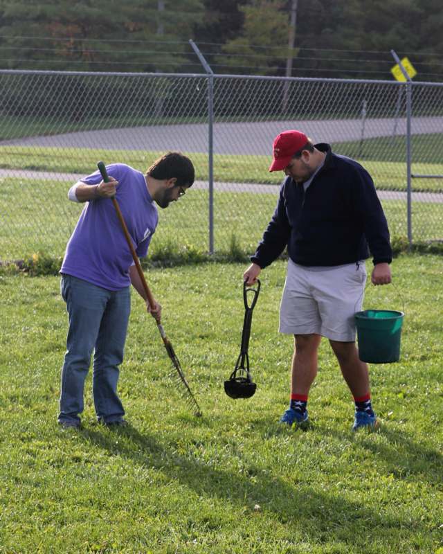 a couple of men holding shovels and a bucket