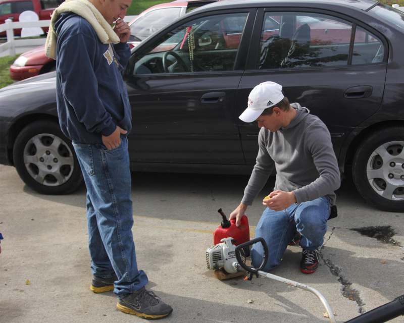 a man kneeling next to a gas cylinder