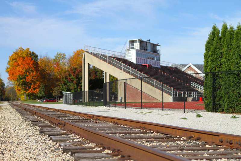train tracks with a bleachers and a stadium