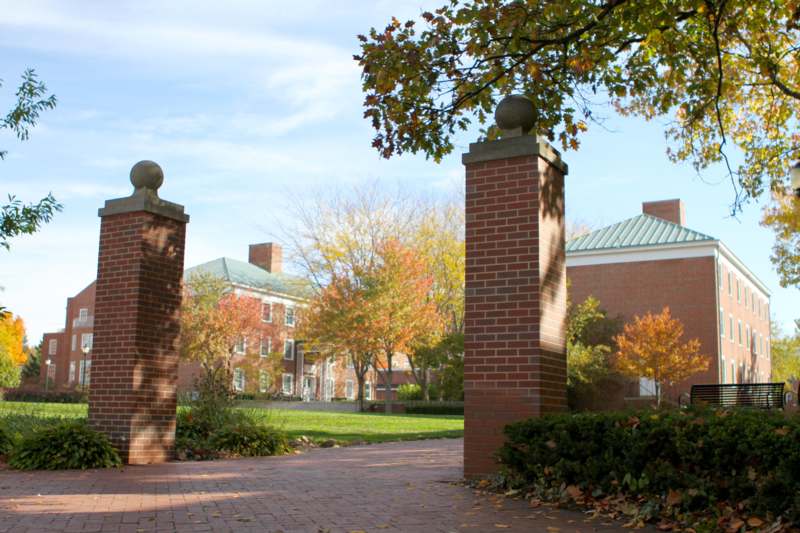 brick pillars with trees and grass in front of a building