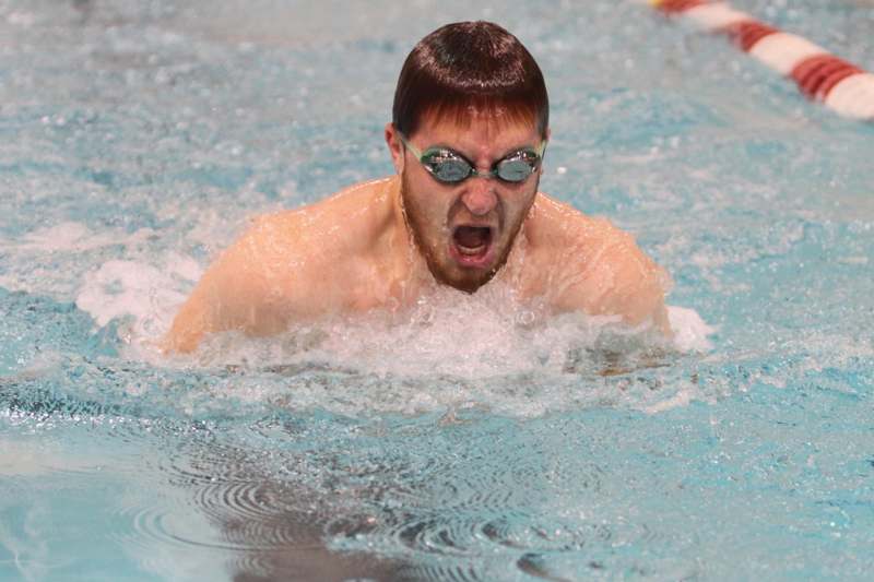 a man wearing goggles and swimming in a pool